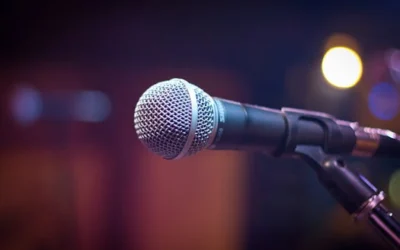 Dynamic microphone on stand with blurred stage lights in background.