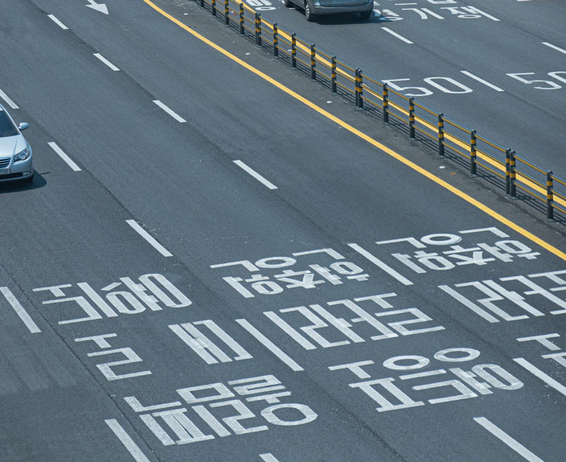 A car driving down a street next to a traffic light