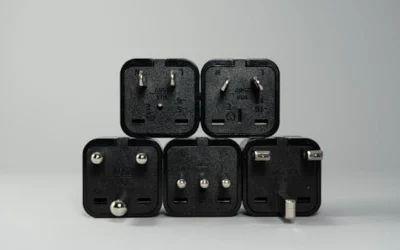 A collection of various black international power plug adapters for global electronics use.