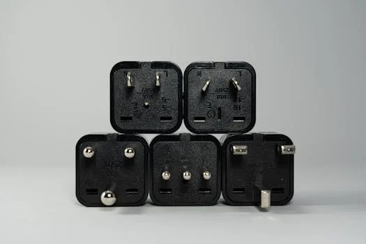A collection of various black international power plug adapters for global electronics use.