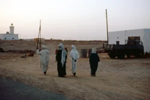 a group of people walking down a dirt road