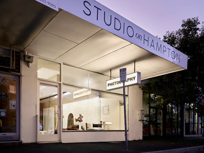 A store front with a street sign in front of it