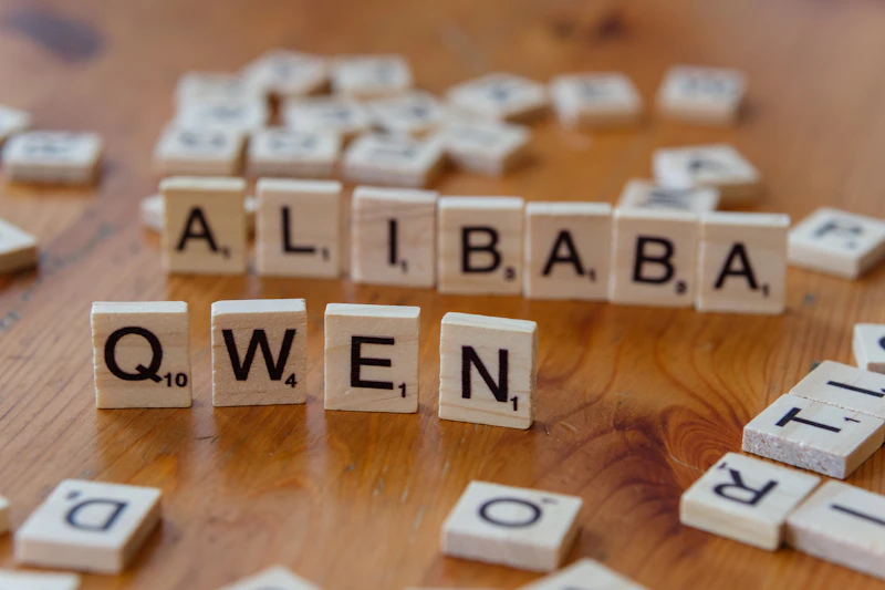 A wooden table topped with scrabble tiles spelling the word alibaba queen