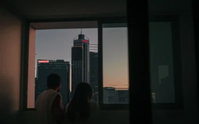 a man and woman looking out a window at a city