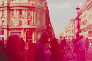 Crowded street scene with people and historic buildings in a vibrant city setting.