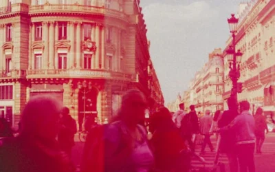 Crowded street scene with people and historic buildings in a vibrant city setting.