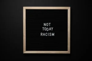Overhead view of phrase Not Today Racism on square framed signboard on black background