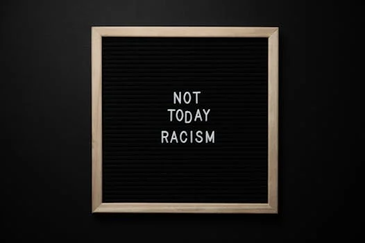 Overhead view of phrase Not Today Racism on square framed signboard on black background