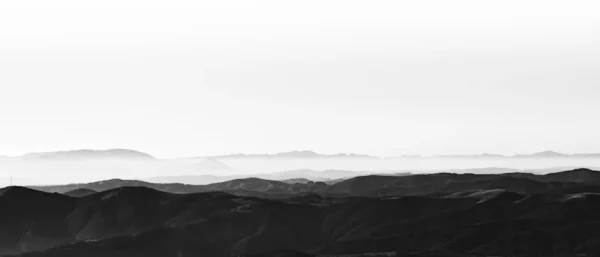 a black and white photo of a mountain range
