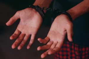 A close-up image showing hands in handcuffs, symbolizing justice and law enforcement.