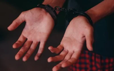 A close-up image showing hands in handcuffs, symbolizing justice and law enforcement.