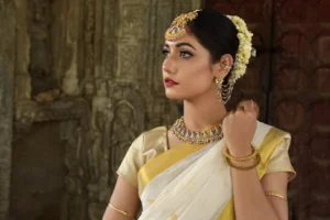 Beautiful Indian woman in traditional saree, adorned with exquisite jewelry, set against historic architecture.
