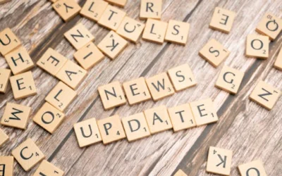 Scrabble tiles spelling 'News Update' on a wooden background, ideal for media and communication concepts.