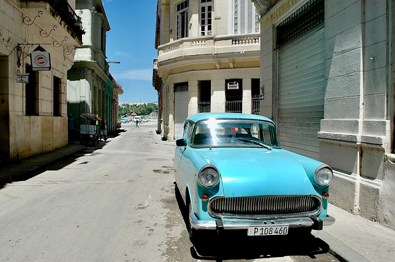 teal vehicle parked beside building