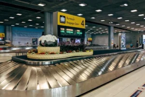 Modern baggage claim area at Suvarnabhumi Airport in Bangkok with luggage carousel and signage.