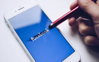 Close-up of a smartphone with a stylus crossing out text on its screen.