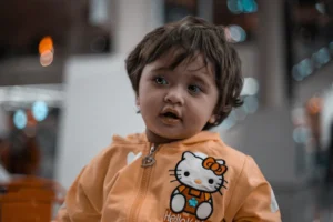 A cute child wearing a hello kitty jacket.