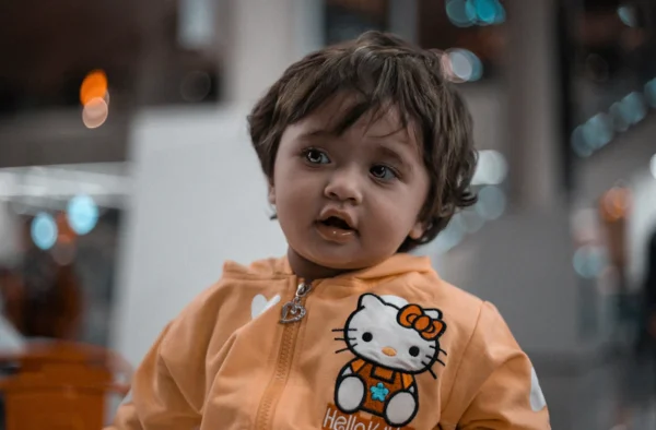 A cute child wearing a hello kitty jacket.