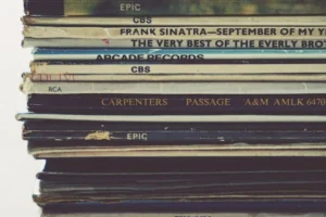 Close-up view of a stack of vintage vinyl records showcasing album spines.