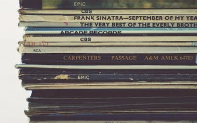 Close-up view of a stack of vintage vinyl records showcasing album spines.