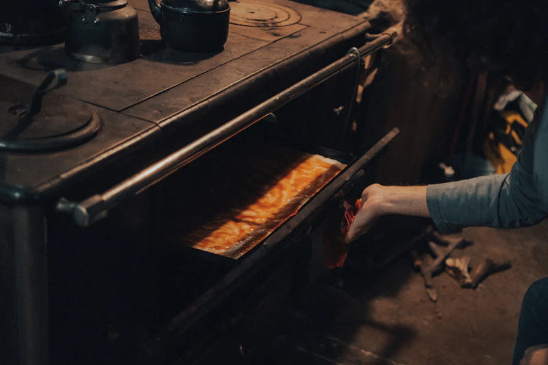 a woman is putting food in an oven