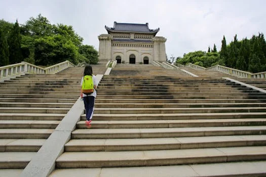 A child with a backpack ascends the stairs to the historic Sun Yat-sen Mausoleum in Nanjing.