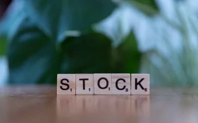 A wooden block spelling the word stock on a table