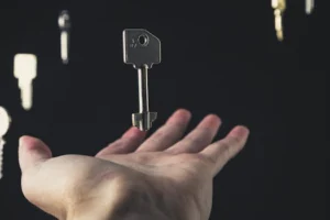 A mysterious scene of keys floating above an open hand against a dark background.