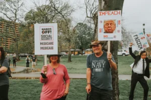 Protesters demonstrate against political issues with signs.