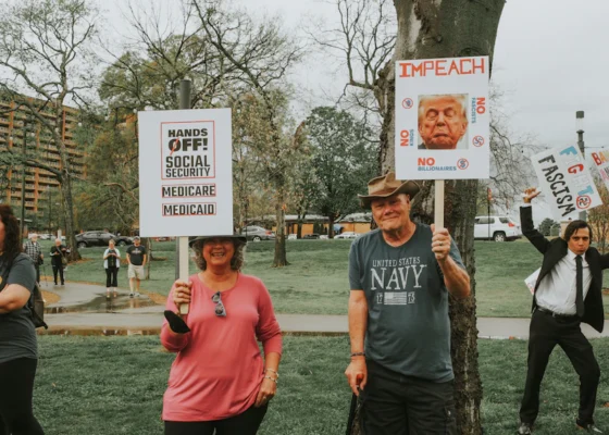 Protesters demonstrate against political issues with signs.