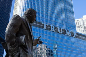 A statue overlooks the trump building.
