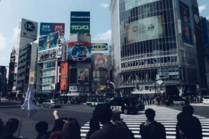Busy shibuya crossing with many buildings.