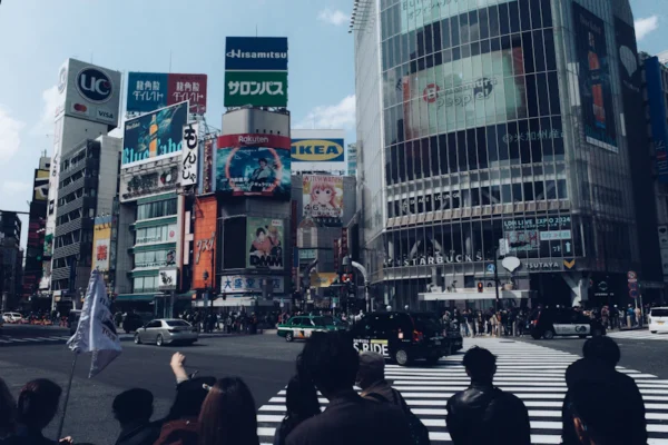 Busy shibuya crossing with many buildings.