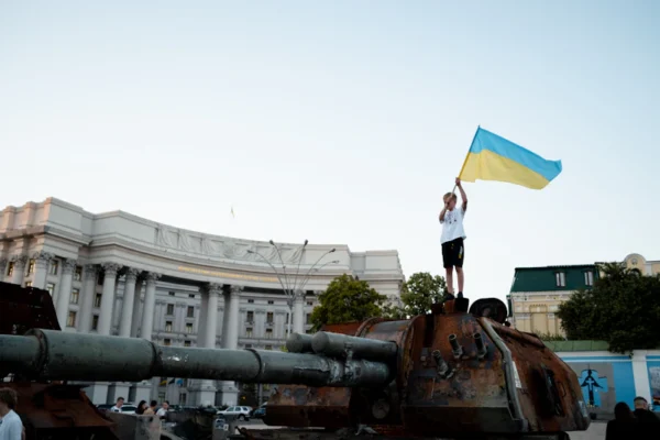 a person standing on a cannon holding a flag