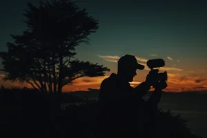 A silhouette of a man with a camera at sunset