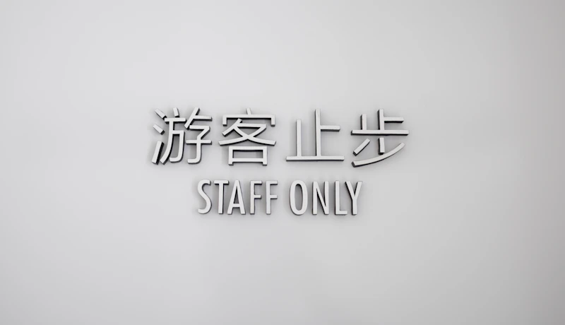 a white wall with a sign that says staff only