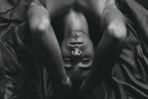 topless man lying on bed