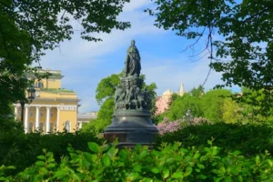 The statue of Catherine the Great surrounded by lush greenery in Saint Petersburg, Russia.