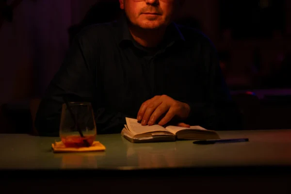 A man sitting at a table with a book