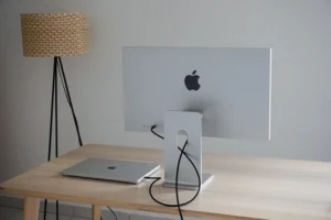an apple computer sitting on top of a wooden desk