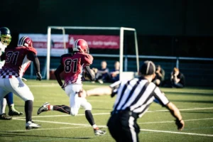 Intense action shot of American football players running on a field during a competitive game.