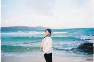 A young woman stands by the vibrant coastal beach in Tuy An Nam, Vietnam.