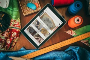 Flat lay of a tablet with sewing supplies, showcasing a digital platform for fabric and patterns.